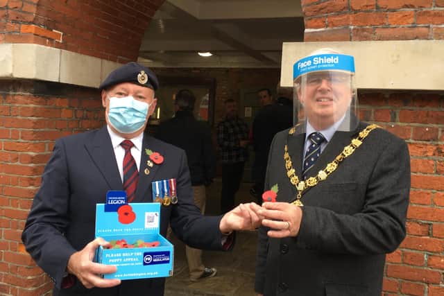 Paul Gaffney, the Poppy Appeal organiser for Central Chichester, presents mayor of Chichester Richard Plowman with a poppy to mark the start of this year's appeal