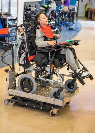 A young person from Chailey Heritage using Martin's powered platform base adapted wheelchair SUS-200311-101238001