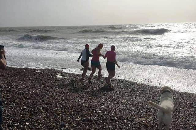 Carolyn Nunn-Hammond, Summer Nunn-Hammond and Justine Winson-Hockley run into the sea together at the start of their 11/11 Challenge