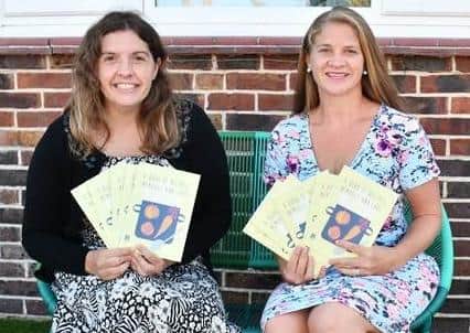 Mel Hargreaves and Lucy Grace with their recipe book, filled with favourites from the community