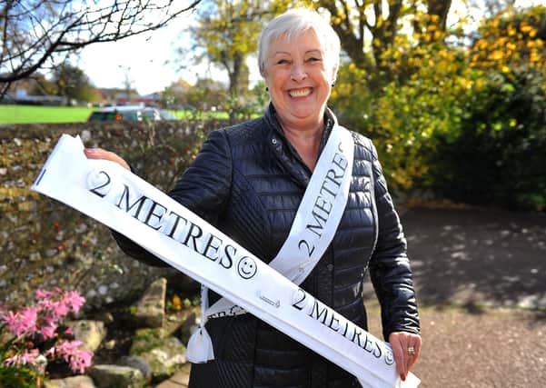 Kim Maybury with her social distancing sashes