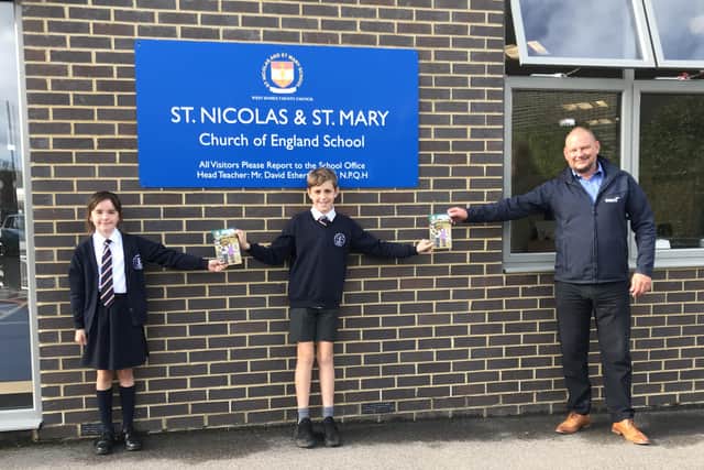 Pupils at St Nicolas and St Mary CE Primary School accept the book donation from Wates Residential