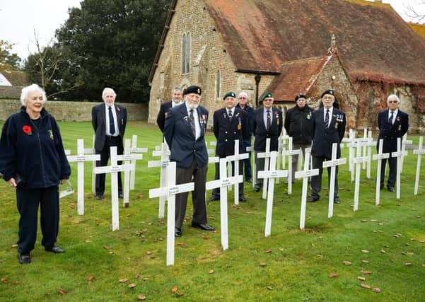 Some of the ex-service men and women who came to St Peter's Church, Selsey, war memorial for a minute's silence on Remembrance Sunday. The 48 wooden crosses have the names of local service men who fell in WWII. Photo: Chris Hatton SUS-200911-180809001
