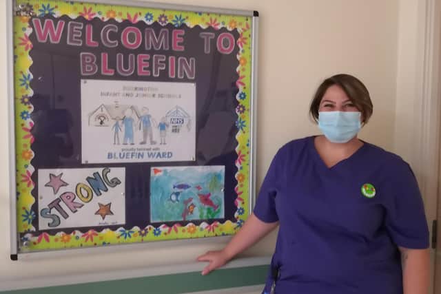 Christie Taylor, senior health play specialist on Bluefin ward, with the winning poster