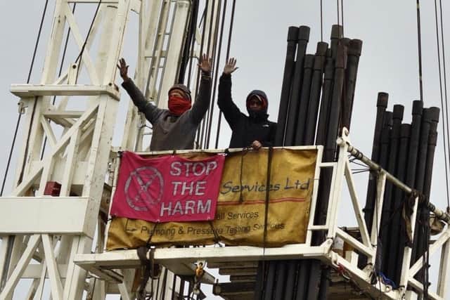 Lindsay Parkin and Alistair Sandell scaled an oil rig to stage a 12-hour protest against plans by UK Oil and Gas (UKOG) to extract fossil fuels at the site.  Pictures: @catarinaemsurdina and XRSurreyPress