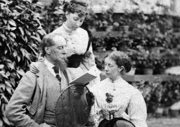 English novelist Charles Dickens (1812 - 1870) seated backwards on a chair as he reads to his daughter and a companion.    (Photo by Hulton Archive/Getty Images) PPP-200225-155428003