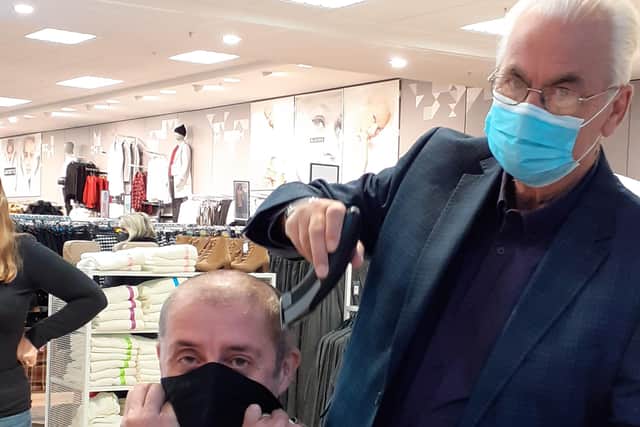 Primark store manager Phil Simpson contemplates life as an “all out baldy” as The Beacon Centre Manager Bill Plumridge helps him on his way.