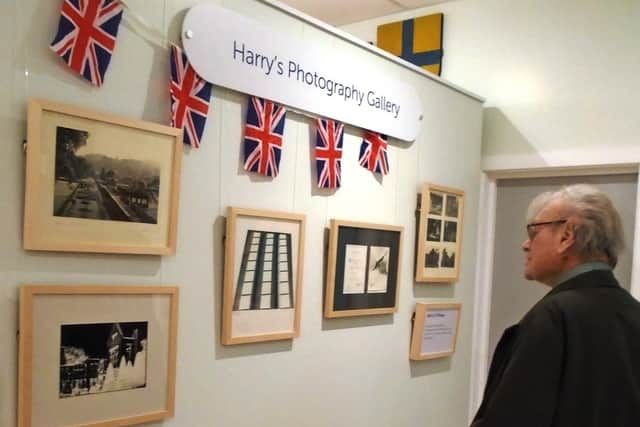 Harry Clark studying the photography gallery, showcasing some of his many pictures of the village over the years