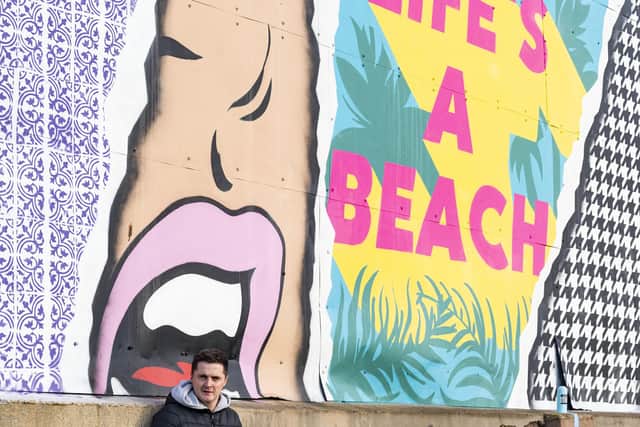 Luke Henley with his mural in front of the Perch in Lancing SUS-210701-142633001