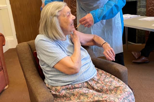 Nanette Buck, resident at Red Oaks, receives a coronavirus vaccine