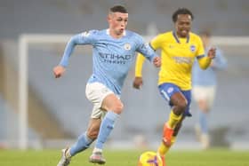 MANCHESTER, ENGLAND - JANUARY 13: Phil Foden of Manchester City makes a break during the Premier League match between Manchester City and Brighton & Hove Albion at Etihad Stadium on January 13, 2021 in Manchester, England. Sporting stadiums around England remain under strict restrictions due to the Coronavirus Pandemic as Government social distancing laws prohibit fans inside venues resulting in games being played behind closed doors. (Photo by Clive Brunskill/Getty Images) SUS-210113-195211001