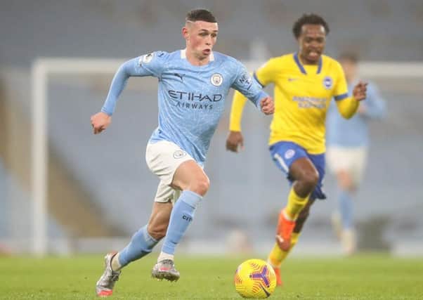 MANCHESTER, ENGLAND - JANUARY 13: Phil Foden of Manchester City makes a break during the Premier League match between Manchester City and Brighton & Hove Albion at Etihad Stadium on January 13, 2021 in Manchester, England. Sporting stadiums around England remain under strict restrictions due to the Coronavirus Pandemic as Government social distancing laws prohibit fans inside venues resulting in games being played behind closed doors. (Photo by Clive Brunskill/Getty Images) SUS-210113-195211001