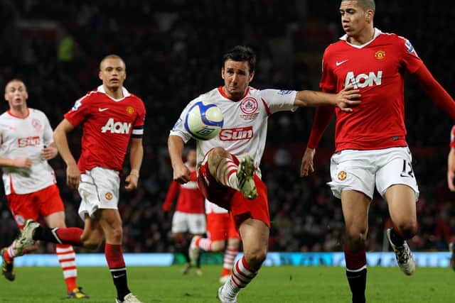 Matt Tubbs holds off Chris Smalling in action at Old Trafford.