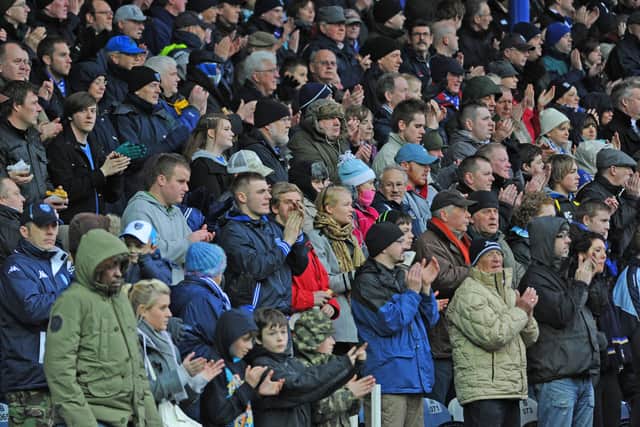 Fans during the one minute applause at Fratton Park in memory of Norman Uprichard. Picture: Sarah Standing 110428-1790