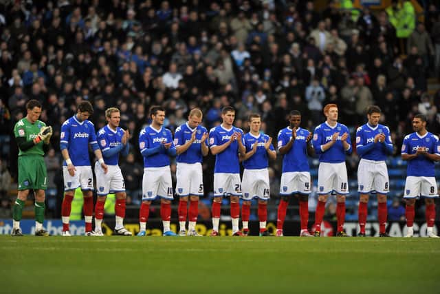 Portsmouth Football Club players join in the one-minute applause for Norman Uprichard. Picture: Steve Reid 110426-388
