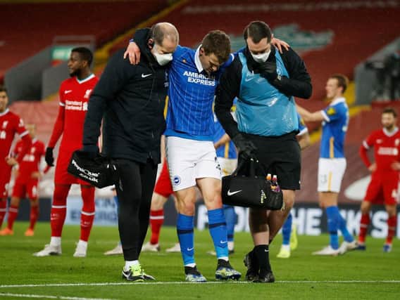 Brighton's Solly March looked in agony as he hobbled off the pitch at Anfield last night