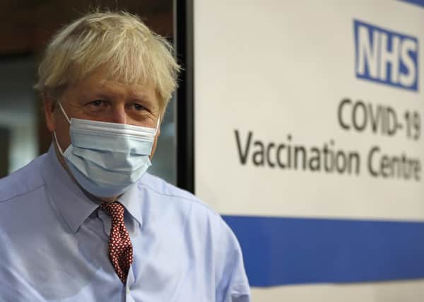LONDON, ENGLAND - DECEMBER 08: British Prime, Minister Boris Johnson looks on after nurse Rebecca Cathersides administered the Pfizer-BioNTech COVID-19 vaccine to Lyn Wheeler at Guy's Hospital at the start of the largest ever immunisation programme in the UK's history on December 8, 2020 in London, United Kingdom. More than 50 hospitals across England were designated as covid-19 vaccine hubs, the first stage of what will be a lengthy vaccination campaign. NHS staff, over-80s, and care home residents will be among the first to receive the Pfizer/BioNTech vaccine, which recently received emergency approval from the country's health authorities. (Photo by Frank Augstein - Pool / Getty Images) PPP-200912-183639003