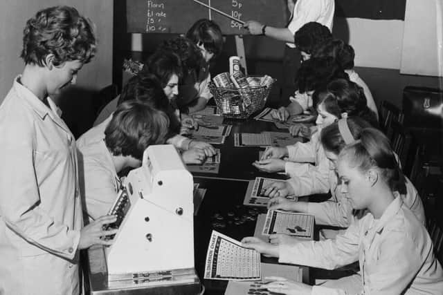Checkout workers at a Fine Fare supermarket studying decimal conversion charts during a training course. Photo by George Hales/Getty Images
