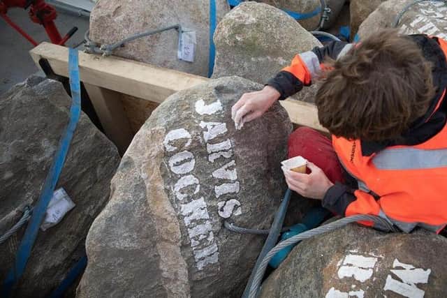 A deck hand paints "Jarvis Cocker" in chalk onto a boulder while working aboard the Greenpeace ship, Esperanza in the English Channel. hoto: Suzanne Plunkett/Greenpeace
