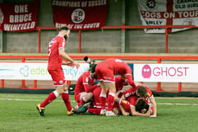 Reds players mob matchwinner James Tilley. Picture by UK Sports Images Ltd/Jamie Evans
