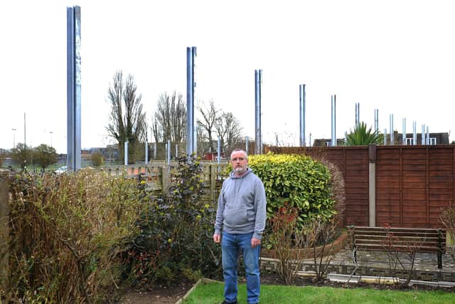 Littlehampton residents in Highdown Drive upset at the height of the acoustic barrier behind their back gardens. Pictured, Warren Kerfoot alongside the 3.5 metre posts. Pic Steve Robards