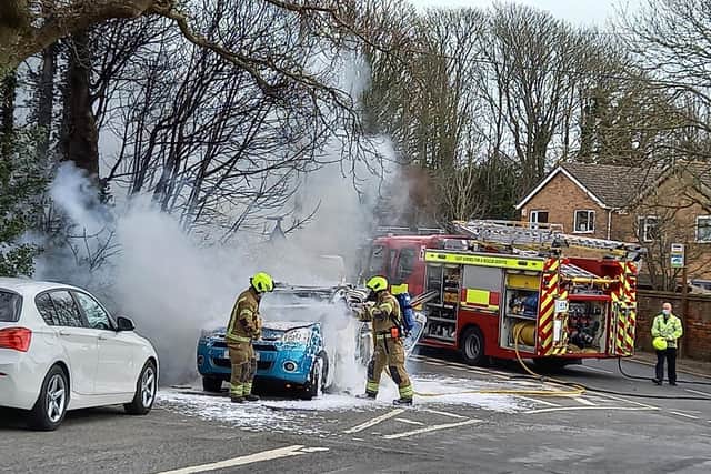 Crews working to put out the car fire this afternoon