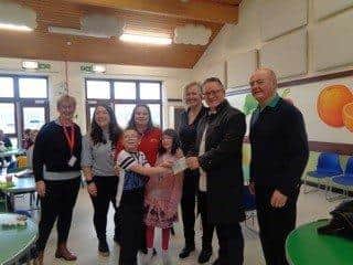 Champion House members present a £245 donation to children, staff and trustees of Adur Special Needs Project