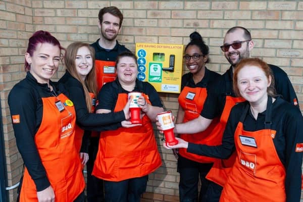 Colleagues at B&Q Burgess Hill mark the installation of a potentially life-saving defibrillator to serve the local community. SUS-201203-163715001