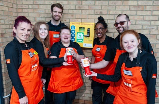 Colleagues at B&Q Burgess Hill mark the installation of a potentially life-saving defibrillator to serve the local community. SUS-201203-163715001