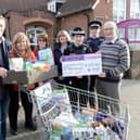 Peter Johnston, chair of the Trustees of the Lancing Foodbank and co-ordinator, right, receives a cheque for 500 from PSCO Steve Evans and Rachel Silver, second and third from right, with fellow Foodbank helpers and supporters