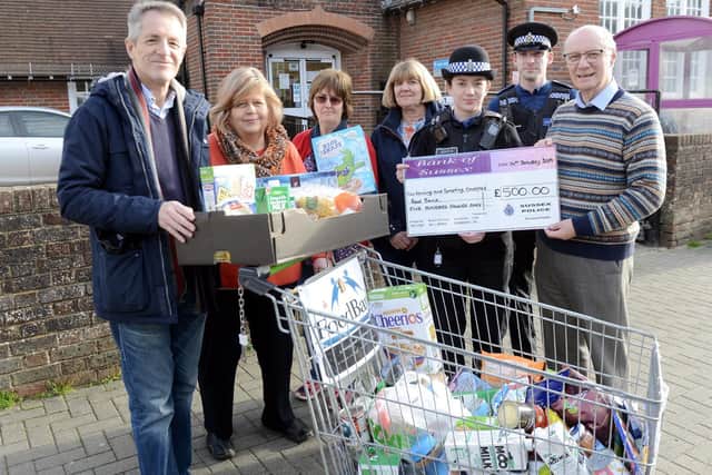 Peter Johnston, chair of the Trustees of the Lancing Foodbank and co-ordinator, right, receives a cheque for 500 from PSCO Steve Evans and Rachel Silver, second and third from right, with fellow Foodbank helpers and supporters