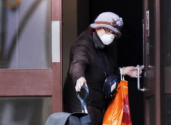 A lady in Eastbourne wearing a face mask and gloves returns to her home with her shopping (Photo by Jon Rigby) SUS-200319-155540001