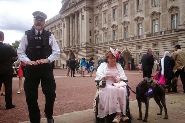 Norah Fisher with her dog, Herbie, outside Buckingham Palace SUS-200414-115858001