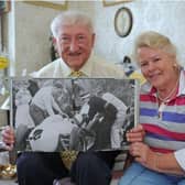 Jim and Annie Strudwick with a picture of them both when they were first on the scene at Goodwood, when Sir Stirling Moss had his accident in 1962. They are pictured in 2014, when they had both retired from the NHS after a total of more than 100 years Picture: Sarah Standing (141147-1529)