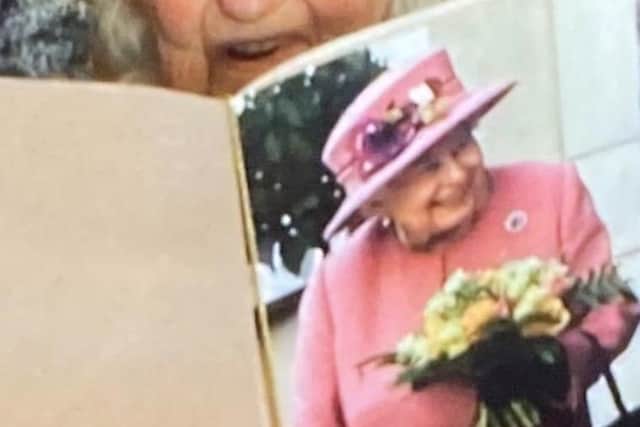 Joan Howell reading her card from the Queen