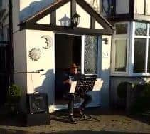 Keith Marsh playing the accordion on his doorstep