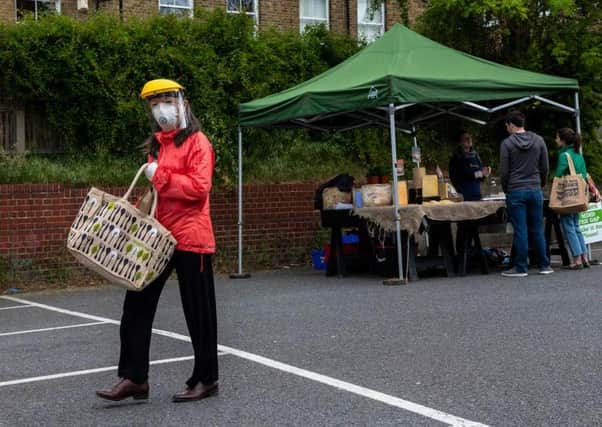 A woman wears a face shield, mask and gloves as she shops at Blackheath Farmers Market in London (Photo: Chris J Ratcliffe/Getty Images)