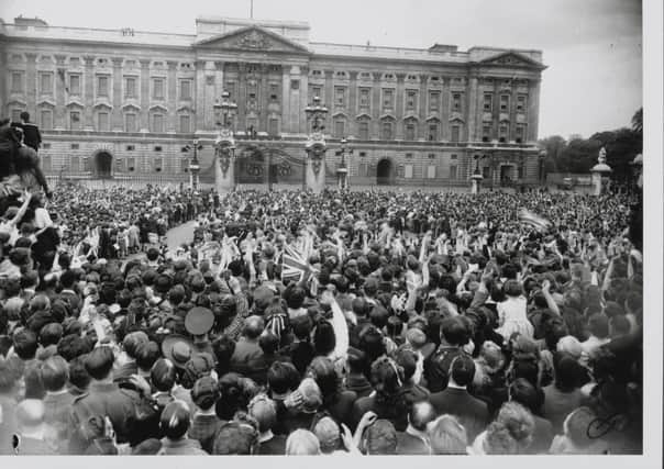 VE Day in London, the crowd gathered outside Buckingham Palace. They cheer and wave as their Majesties the King and Queen with the Princesses Elizabeth and Margaret Rose appear on the balcony. (Photo by Hulton Archive/Getty Images) PPP-191220-154019003