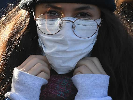 A woman wears a protective face mask. Picture: DANIEL LEAL-OLIVAS/AFP via Getty Images
