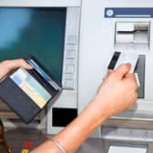 Cash withdrawal. Woman's hand inserting plastic card Visa into the ATM PPP-150821-164241001