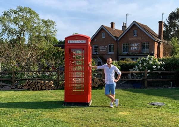 Daniel Webber with the phone box at the Bat and Ball pub