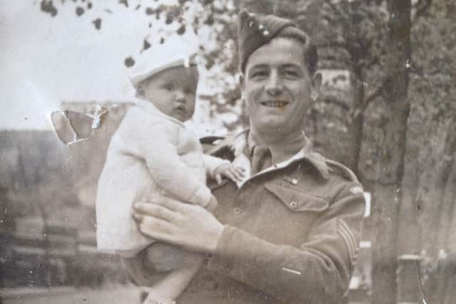 Alf Heath in uniform, holding his daughter Carole