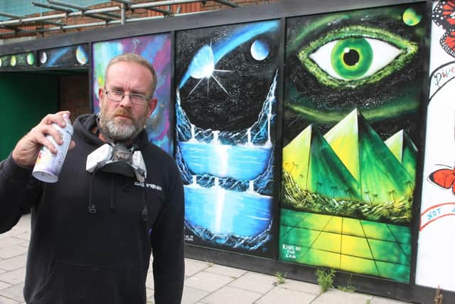 'King of the Can' street artist Tony Eadie and artwork he created on hoardings outside an office building in North Street, Horsham. Photo by Derek Martin Photography. SUS-190813-165146008