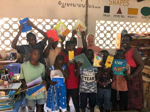 Pictured are pupils from Mnarani Primary School with Christine Bayliss with their books and stationery and planting up the vegetable garden SUS-200106-124626001