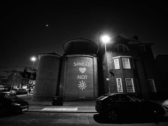 Artist Mike Dicks projected this message onto a wall of a church in Brighton & Hove. (Photo by Mike Hewitt/Getty Images)