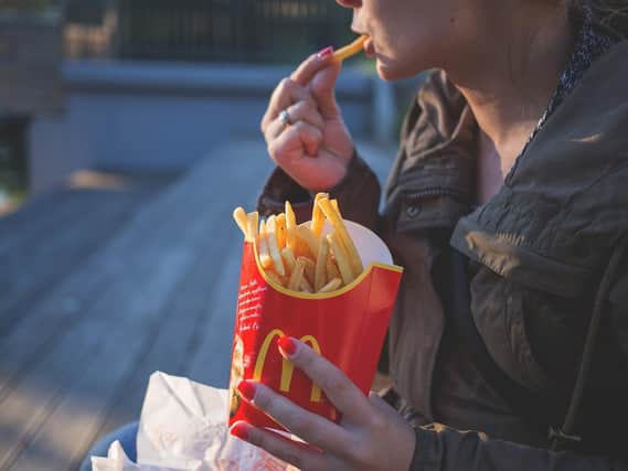 A woman eating fries from McDonald's