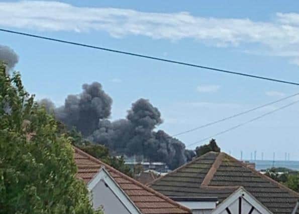 Thick black plumes of smoke are rising from the industrial estate