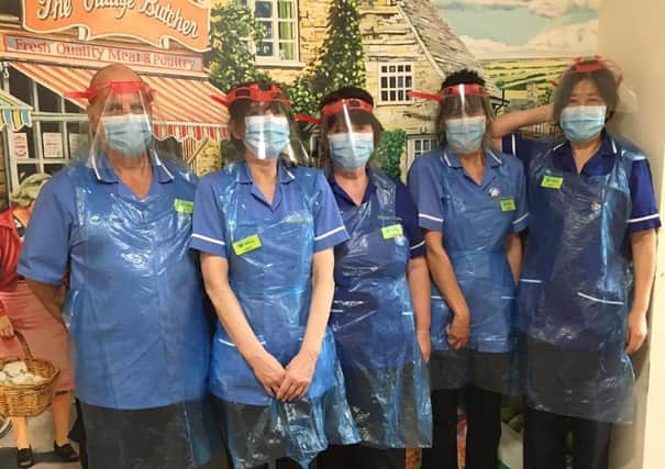 Pictured are the care team at Edendale Lodge care home fashioning the indispensable donation from Claverham College Design and Technology Department. SUS-200623-101842001