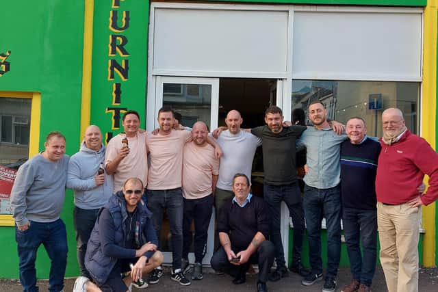 Steve Philbey, centre, with friends and visitors to his shop in St Leonards. Picture by Danny Wood SUS-211110-112428001
