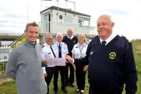 Liam Cornford presents the cheque to station manager Stephen Hand watched by National Coastwatch Shoreham volunteers. Picture: Steve Robards SR2110152